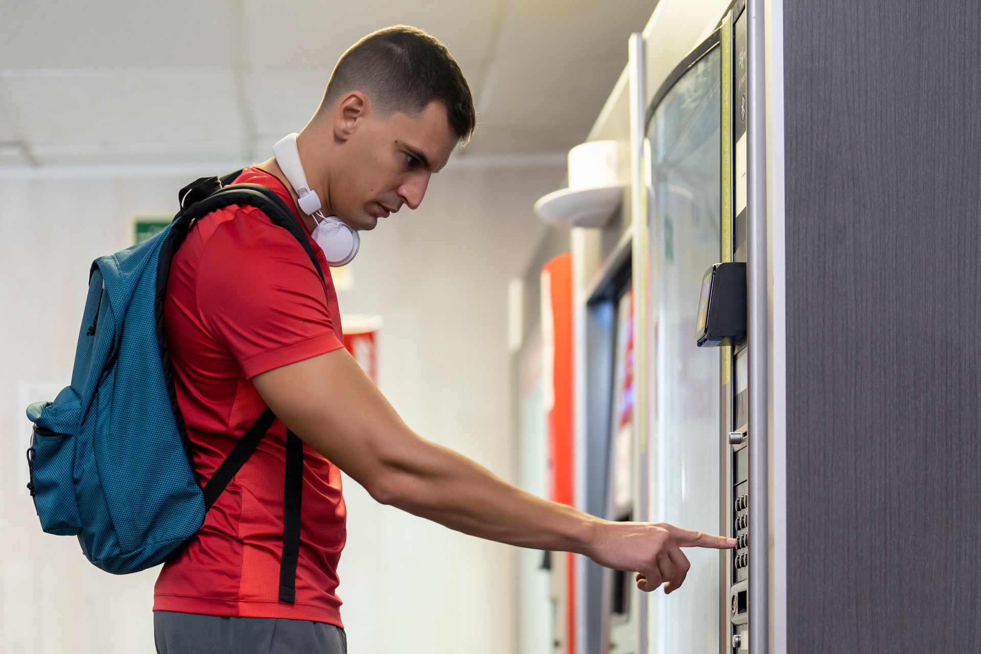 Athlete in gym consuming drink from food vending machine